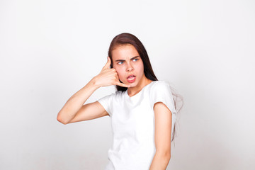 Young woman making a call me gesture