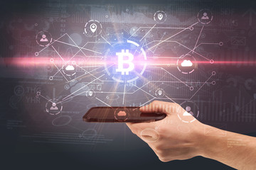 Hand using phone with cryptocurrency bitcoin link network and online concept
