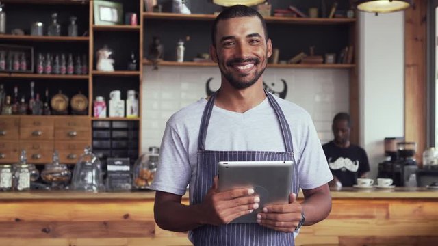 Happy cafe owner using digital tablet