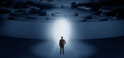 Businessman getting ready to enter a concentric labyrinth with lighted entrance concept
