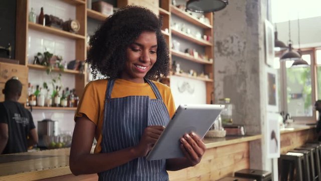 Female owner using digital tablet in cafe