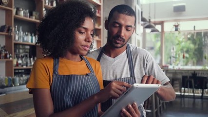 Male and female owner working together in cafe - Powered by Adobe