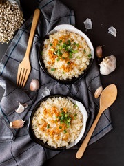 Garlic fried rice in ceramic plate with wood spoon on black background.