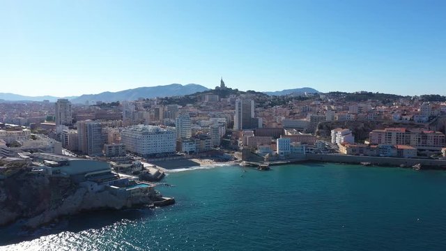 Marseille aerial back traveling from Catalan beach Old Port of Marseille and basilic in background. Sunny day 
