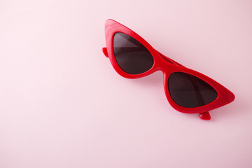 Red retro sunglasses on pink background