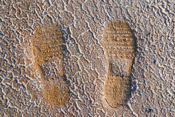 Close up two footprints on texture background of saline soil
