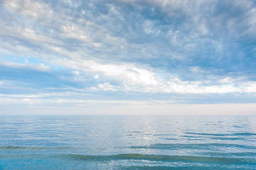 Obraz premium Seascape with sea horizon and blue sky. Background. Painterly seascape scene with relaxing sunset colours.