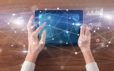 Hand using tablet with linking graphs charts  report and informational flow concept
