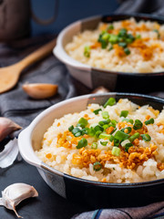 Garlic fried rice in ceramic plate with wood spoon on black background.