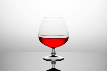 A glass of red wine. White background. Gradient