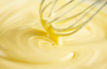 White chocolate. Melted liquid white chocolate mixing with a wisk. Closeup of molten liquid hot...