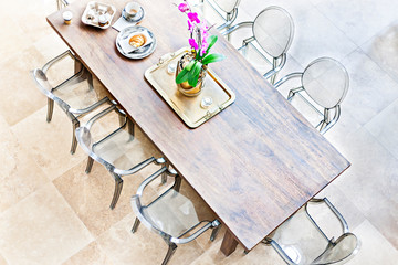 Wooden dining table above view with plastic chairs