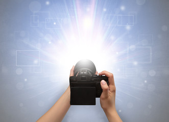 Naked hand taking picture with digital camera and glowing flash concept
