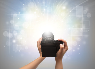 Naked hand taking picture with digital camera and glowing flash concept
