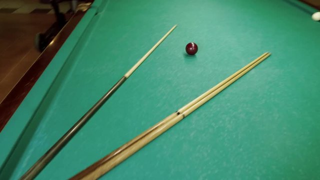 Men playing billiards, hitting the balls with a cue into pockets on a billiard table. 4K