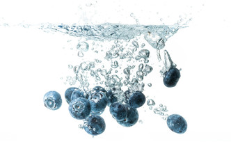 Blueberries sinking underwater with air bubbles isolated on white background