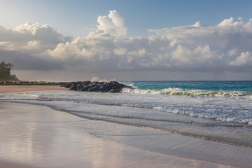 Waves lapping a sandy beach on the Caribbean island of Barbados, taken with morning light
