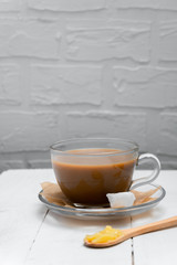 Homemade bulletproof coffee with ghee butter and coconut oil on white wooden background. Image with copy space.
