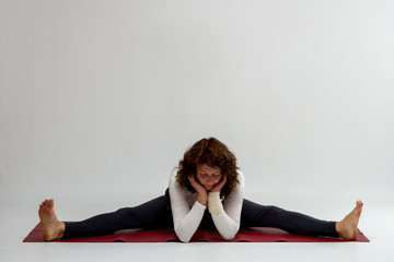 Studio shot of a woman doing yoga exercises on white background