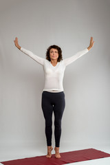 Studio shot of a woman doing yoga exercises on white background