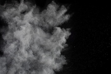 White powder explosion.Freeze motion of white dust particles on black background.