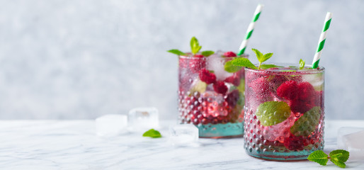 Raspberry cocktail, fizz, lemonade, ice tea with fresh mint on marble background. Copy space.