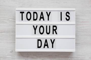 Modern board with text 'Today is your day' on a white wooden background, top view. Flat lay, overhead, from above. Close-up.