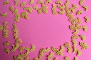 texture of pasta in the form of an arc on a pink background
