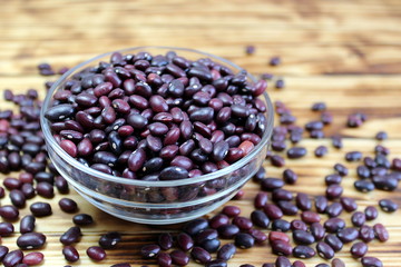 Red beans lie in a glass plate and next to a scattered