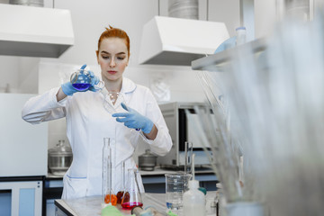 red-haired woman works in the medical laboratory