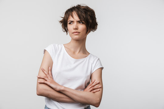 Portrait of angry woman with short brown hair in basic t-shirt frowning and looking at camera