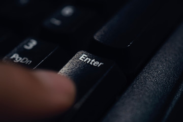 Finger pressing enter key close up