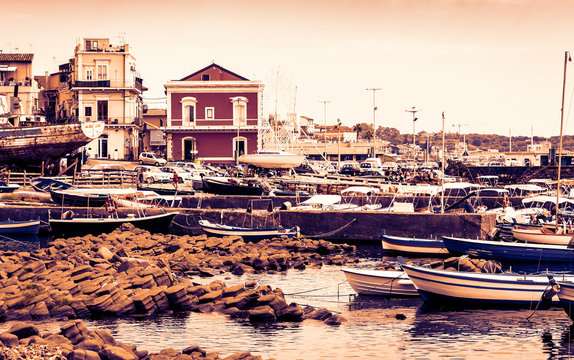 Sunset in Sicily, Acitrezza harbor with fisher boats next to Cyclops islands, Catania.