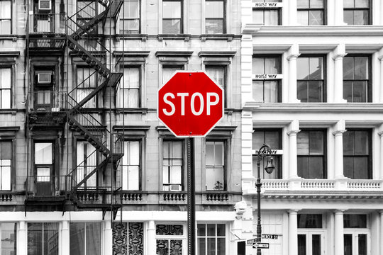 Red stop sign against background of old black and white buildings in SoHo Manhattan, New York City
