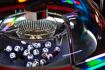 Black and white lottery balls in a rotating bingo machine. Number 3