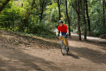 Naklejka premium A cyclist rides on a road bicycle, going up hill.