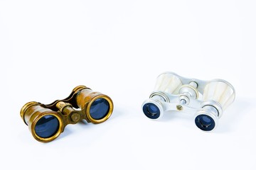 Two vintage binoculars on white background - brass metal body, silver grip