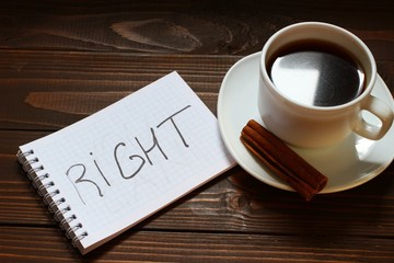 Right inscription and word in a notebook near a cup of coffee