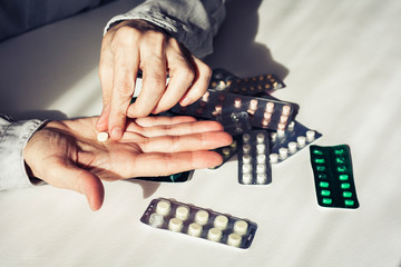 Medicine pills or capsules with old woman&rsquo;s hands on white background with copy space. Blister pack.