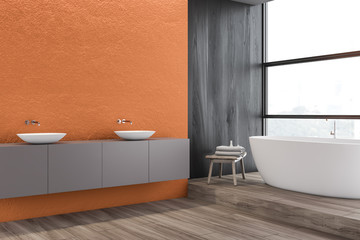 Orange bathroom corner, double sink and tub