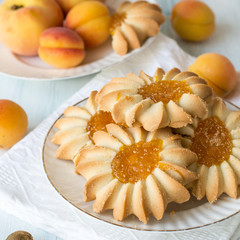 Sweet dessert. Homemade cookies filled with apricot jam on a round white plate on an old wooden table.