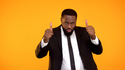 Sexy african businessman showing thumbs-up, celebrating successful startup, win