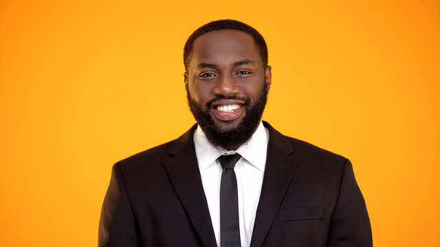 Black businessman in suit smiling and looking to camera, sales representative