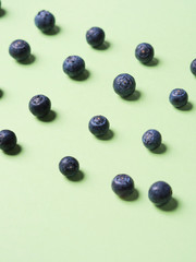 Pattern of fresh blueberries in on pastel green background. Healthy breakfast concept
