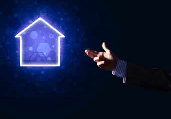 Conceptual image with hand pointing at house or main page icon on dark background