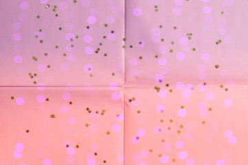 Pink coral wrapping paper background with star confetti and sparkle lights. Geometry festive abstract art concept backdrop.