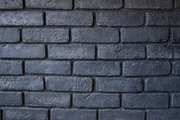 Fragment of a brick wall. The wall is painted black. Background