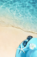 Hat and sunglasses on the sandy beach. Summer background