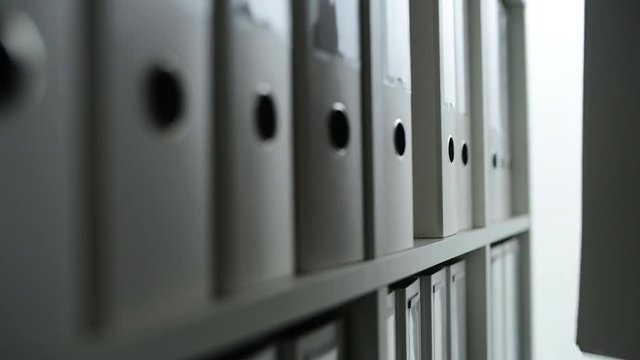 Businesswoman browsing through ring binder file documentation archives