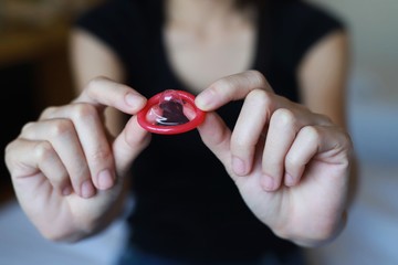 Women hold condoms about the prevention of sexually transmitted diseases and world AIDS